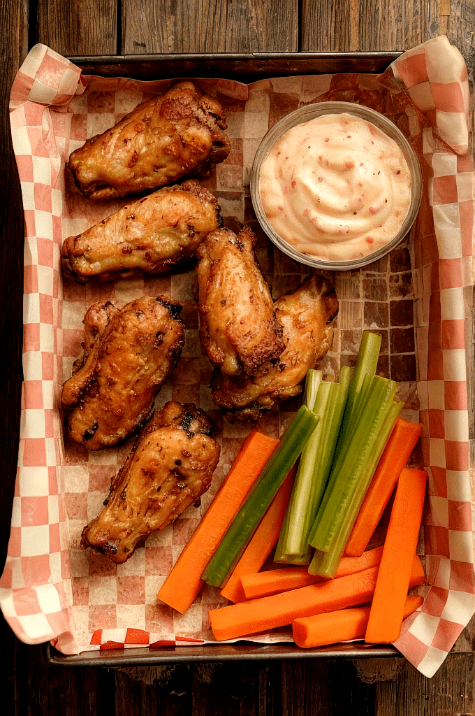 Air fryer chicken wings on tray with dip and veggies