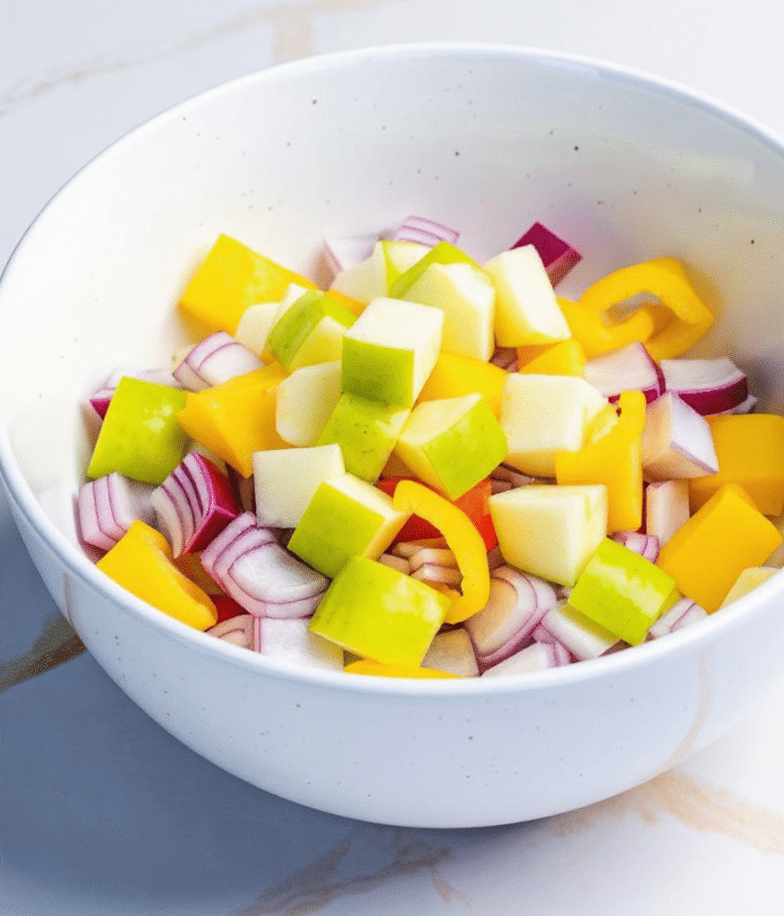 Chopped vegetables and apple cubes prepped for chicken apple sausage air fryer recipe
