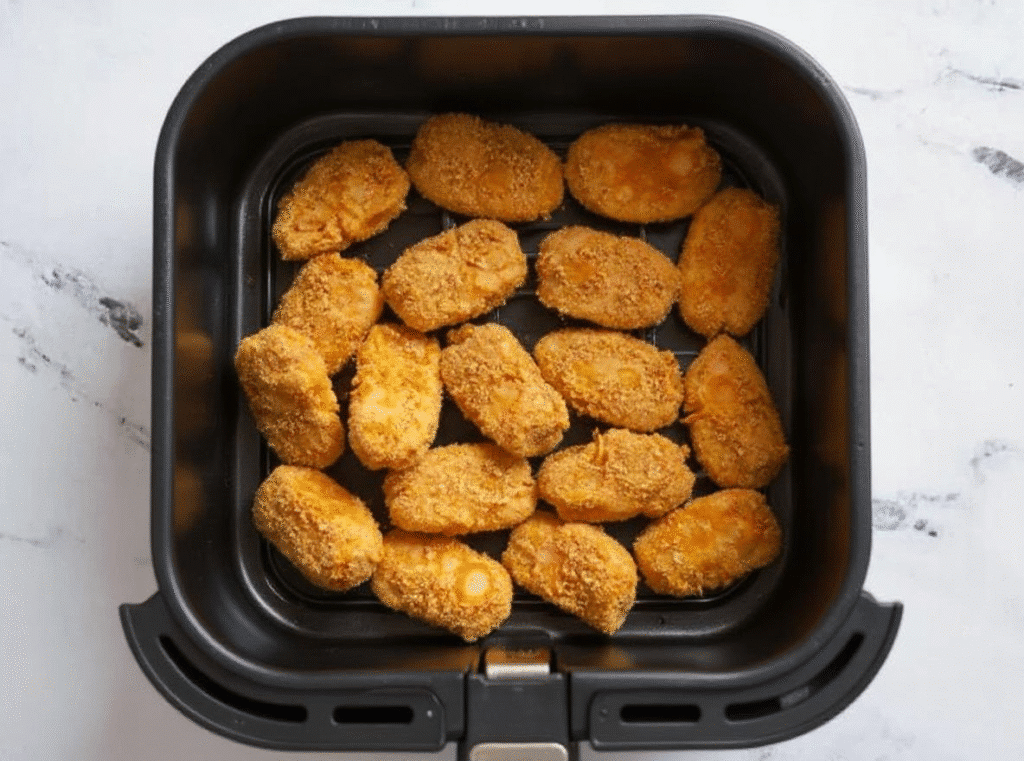 Crispy golden chicken nuggets served in a round white bowl.