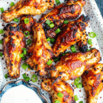 Crispy Ranch Air Fryer Chicken Wings on a serving plate with dipping sauce