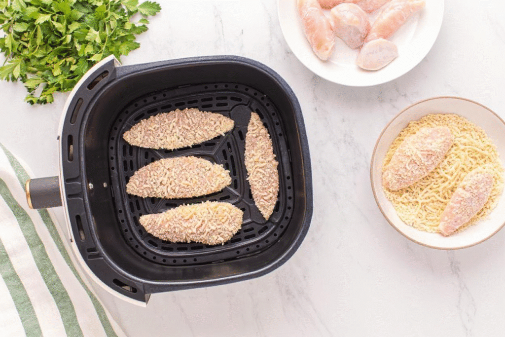 Breaded chicken arranged inside the air fryer basket
